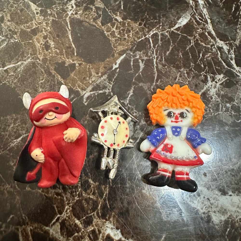 Random set of 3 brooches - raggedy Ann, clock, and red devil